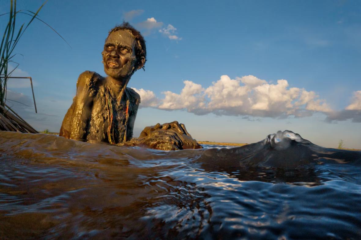 Daasanach woman slathered in mud by a Daasanach healer